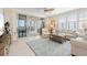 Bright living room featuring tile floors, a ceiling fan, and sliding glass doors to the outdoor patio with water views at 1260 Dolphin Bay Way # 404, Sarasota, FL 34242