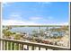 Scenic view of a marina, a bay, and parked cars, visible from a balcony, under a beautiful blue sky at 1260 Dolphin Bay Way # 404, Sarasota, FL 34242