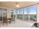Enclosed outdoor patio with tiled floors, ample sunlight, ceiling fan, dining table, and marina views at 1260 Dolphin Bay Way # 404, Sarasota, FL 34242