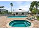 Community pool and hot tub surrounded by palm trees and lounge chairs at 1260 Dolphin Bay Way # 404, Sarasota, FL 34242