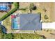 Aerial view of the house showcasing a screened-in pool, manicured lawn and pristine gray roof at 145 Baytree Dr, Rotonda West, FL 33947