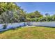 Lush backyard featuring a manicured lawn, privacy fence, and secluded seating area surrounded by foliage at 145 Baytree Dr, Rotonda West, FL 33947