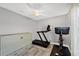 Bright bedroom featuring hardwood floors, ceiling fan, Murphy bed, treadmill, and exercise bike at 145 Baytree Dr, Rotonda West, FL 33947
