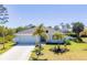 Charming single-story home boasts a well-manicured lawn, complemented by young palm trees at 145 Baytree Dr, Rotonda West, FL 33947