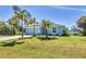Charming single-story home featuring a well-manicured lawn, a two car garage, and lush tropical landscaping creating curb appeal at 145 Baytree Dr, Rotonda West, FL 33947