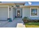 Inviting front entrance with a well-lit porch, neutral paint, and colorful planters creating a warm welcome at 145 Baytree Dr, Rotonda West, FL 33947