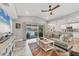 Open-concept living room with stylish decor, a ceiling fan, and sliding door access to the outdoor patio at 145 Baytree Dr, Rotonda West, FL 33947