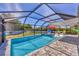 Sparkling screened-in pool and spa, surrounded by a spacious deck, landscaping, and ample outdoor seating at 145 Baytree Dr, Rotonda West, FL 33947