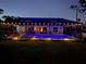 Night view of the screened-in pool with lights, lounge furniture, and view into home at 145 Baytree Dr, Rotonda West, FL 33947