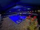 Relaxing screened pool with chairs, umbrella, and lounge area for outdoor enjoyment day or night at 145 Baytree Dr, Rotonda West, FL 33947
