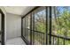 Relaxing outdoor balcony with black metal railings and sliding glass doors overlooking lush trees at 1610 Treehouse Cir # T130, Sarasota, FL 34231