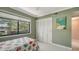 Bright bedroom with a large window with nature views, neutral walls, closet and ceiling fan at 1610 Treehouse Cir # T130, Sarasota, FL 34231