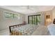 Bright bedroom featuring a ceiling fan and sliding glass doors to a balcony with nature views at 1610 Treehouse Cir # T130, Sarasota, FL 34231