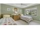 Bedroom with twin beds, dresser, nature views through a window and green walls at 1610 Treehouse Cir # T130, Sarasota, FL 34231