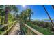 Picturesque boardwalk leading to serene waters, surrounded by lush greenery and palm trees in a waterfront community at 1610 Treehouse Cir # T130, Sarasota, FL 34231
