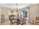 A traditional dining room features a wood table, elegant chandelier, and sliding doors to a private outdoor space at 1610 Treehouse Cir # T130, Sarasota, FL 34231