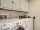 A functional laundry area featuring a white Maytag washer and dryer with overhead cabinets at 1610 Treehouse Cir # T130, Sarasota, FL 34231
