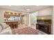An open-concept living area blends seamlessly into the kitchen with a beach view on the television at 1610 Treehouse Cir # T130, Sarasota, FL 34231