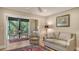 Living area with glass doors opening to screened lanai with outdoor seating, and beautiful natural views at 1610 Treehouse Cir # T130, Sarasota, FL 34231