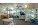 An open meeting area with large windows, a piano, a tv, and tables and chairs for gatherings at 1610 Treehouse Cir # T130, Sarasota, FL 34231