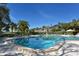 Sparkling community pool surrounded by lush greenery and mature trees offering a luxurious outdoor experience at 1610 Treehouse Cir # T130, Sarasota, FL 34231