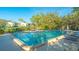 Community pool featuring lounge chairs, clear blue water, and well-maintained landscaping at 1610 Treehouse Cir # T130, Sarasota, FL 34231