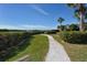 Beautifully landscaped walking path surrounded by lush greenery with serene waterfront views in a waterfront community at 1610 Treehouse Cir # T130, Sarasota, FL 34231