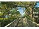 Scenic community walkway lined with lush trees leading towards the waterfront at 1610 Treehouse Cir # T130, Sarasota, FL 34231