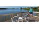 Scenic water view from a wooden deck with chairs, featuring calm waters and natural surroundings at 1610 Treehouse Cir # T130, Sarasota, FL 34231