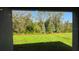 Tranquil view of a lush green backyard from a covered patio area at 17060 James Trl, Parrish, FL 34219