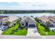 Aerial view of a home with a gray tile roof near a lake in a residential community at 17604 Hickok Belt Loop, Bradenton, FL 34211