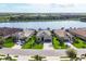 Aerial view of three homes with manicured lawns and a serene lake backdrop in a residential community at 17604 Hickok Belt Loop, Bradenton, FL 34211