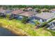 Aerial view of a home with a screened-in pool and spa, surrounded by lush landscaping and manicured lawns at 17604 Hickok Belt Loop, Bradenton, FL 34211