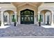 Elegant clubhouse entrance with stone walkway, large glass doors, and manicured landscaping at 17604 Hickok Belt Loop, Bradenton, FL 34211