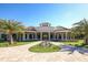 Elegant clubhouse exterior with a circular driveway, manicured landscaping, and impressive architectural details at 17604 Hickok Belt Loop, Bradenton, FL 34211