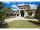 Charming exterior of a building with a tile roof, manicured lawn, and lush landscaping at 17604 Hickok Belt Loop, Bradenton, FL 34211