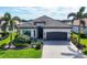 Charming single-story home featuring a beautifully landscaped yard and a gray tile roof at 17604 Hickok Belt Loop, Bradenton, FL 34211