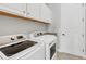 Laundry room with white washer and dryer, upper cabinets, a utility sink, and tile flooring at 17604 Hickok Belt Loop, Bradenton, FL 34211