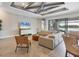 Bright living room featuring stylish furniture, a coffered ceiling, and large windows with a lake view at 17604 Hickok Belt Loop, Bradenton, FL 34211