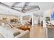 Open-concept living room and kitchen area with dining room, decorative ceilings, and tile floors at 17604 Hickok Belt Loop, Bradenton, FL 34211