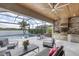 Screened patio featuring an outdoor kitchen, grill, seating, and a swimming pool with a lake view at 17604 Hickok Belt Loop, Bradenton, FL 34211