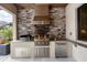This outdoor kitchen features stone accents, granite countertops, stainless steel appliances, and a built-in grill at 17604 Hickok Belt Loop, Bradenton, FL 34211