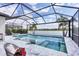 Gorgeous screened-in pool overlooking the water, featuring built-in loungers and a connected spa at 17604 Hickok Belt Loop, Bradenton, FL 34211