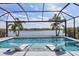 Inviting swimming pool with submerged chaise lounges and a serene lake view through the screened enclosure at 17604 Hickok Belt Loop, Bradenton, FL 34211
