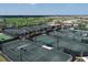 Aerial view of multiple, well-maintained tennis courts with shaded benches and surrounding greenery at 17604 Hickok Belt Loop, Bradenton, FL 34211