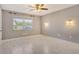 Neutral bedroom featuring a ceiling fan, light fixtures, and natural light from a window at 2332 Canalbluff Pl # 298, Sarasota, FL 34231