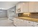 Bright kitchen with granite counters, white cabinetry and backsplash is open to the living area at 2332 Canalbluff Pl # 298, Sarasota, FL 34231