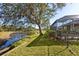 The backyard boasts a scenic pond view, complemented by mature trees and lush greenery at 2439 Sonoma W Dr, Nokomis, FL 34275