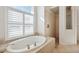 Large soaking tub and separate shower featured in this bright primary bathroom at 2439 Sonoma W Dr, Nokomis, FL 34275
