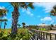 Scenic boardwalk view leading to Nokomis Beach, showcasing lush greenery, open pavilions and clear blue skies at 2439 Sonoma W Dr, Nokomis, FL 34275